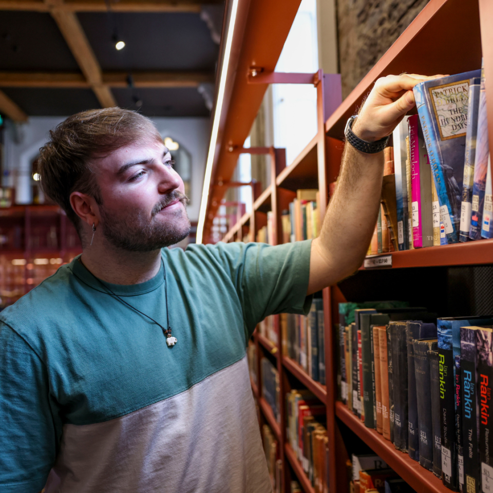 student browsing books in Woodlock Hall library