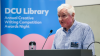 A man speaks from a lectern