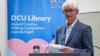 A man speaks from a lectern