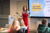 A woman speaking to a class of primary school age children