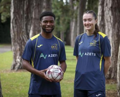 Male and female soccer players posing