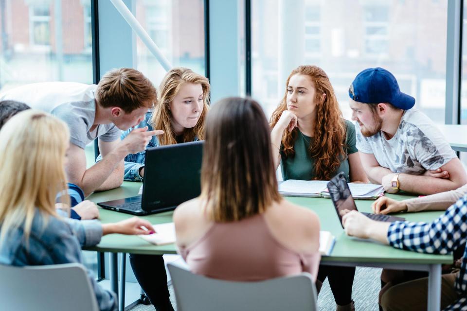 Students working together around a laptop.