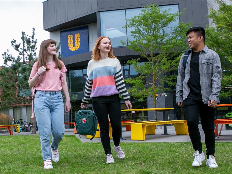 Image of three students walking around campus