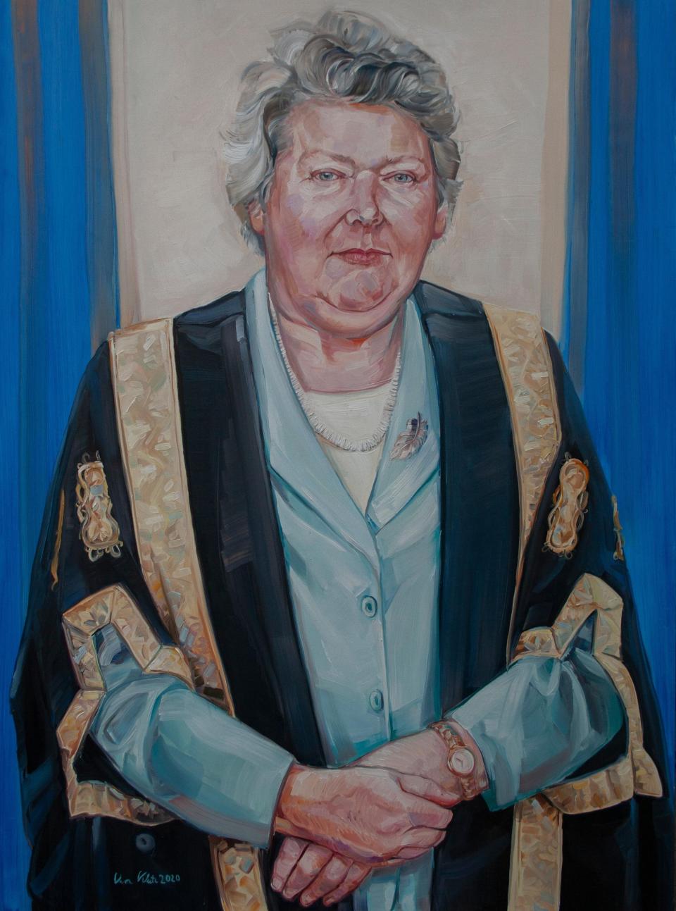 Ms Justice Mella Carroll - painting of a woman with grey hair wearing a Blue blouse and graduation gown