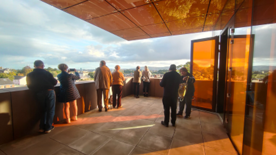 People standing on a balcony looking out 