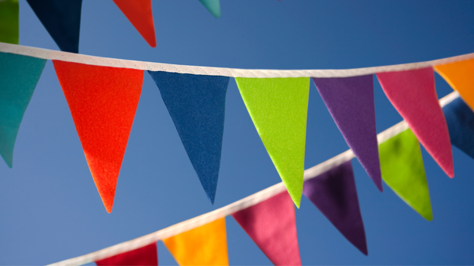 Colourful bunting hanging in front of blue sky