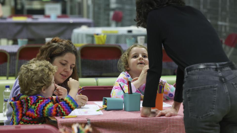 Two children and two adults sitting creating art