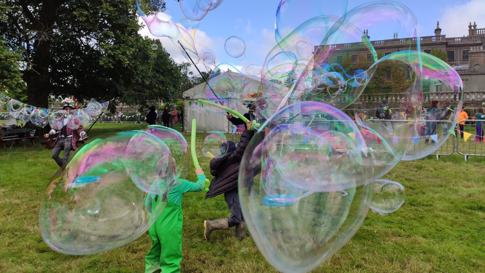 Giant Bubbles being created in a green field 