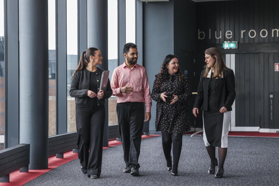 Four colleagues walking in DCU's The Helix