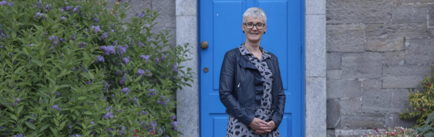 anne tannam standing in front of a blue door