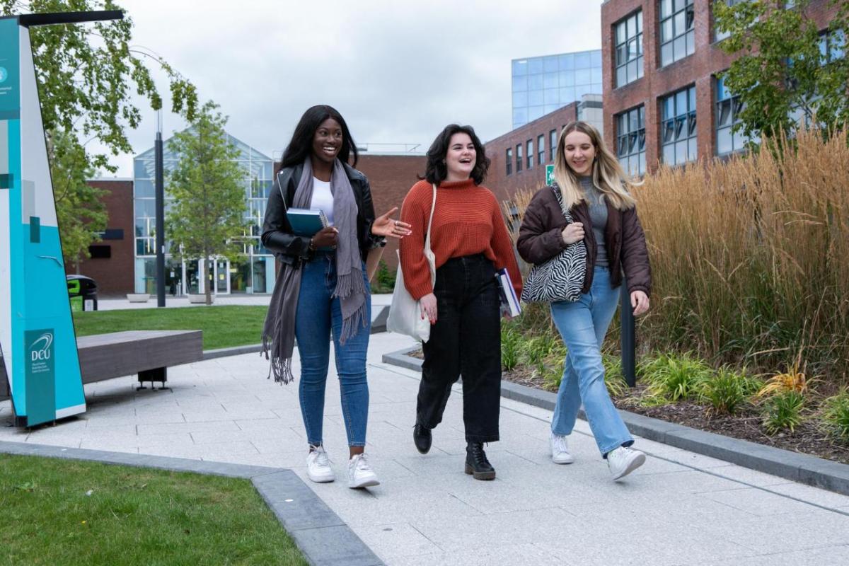 Three students walking and talking on campus