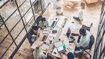 Colleagues collaborating at a work desk 