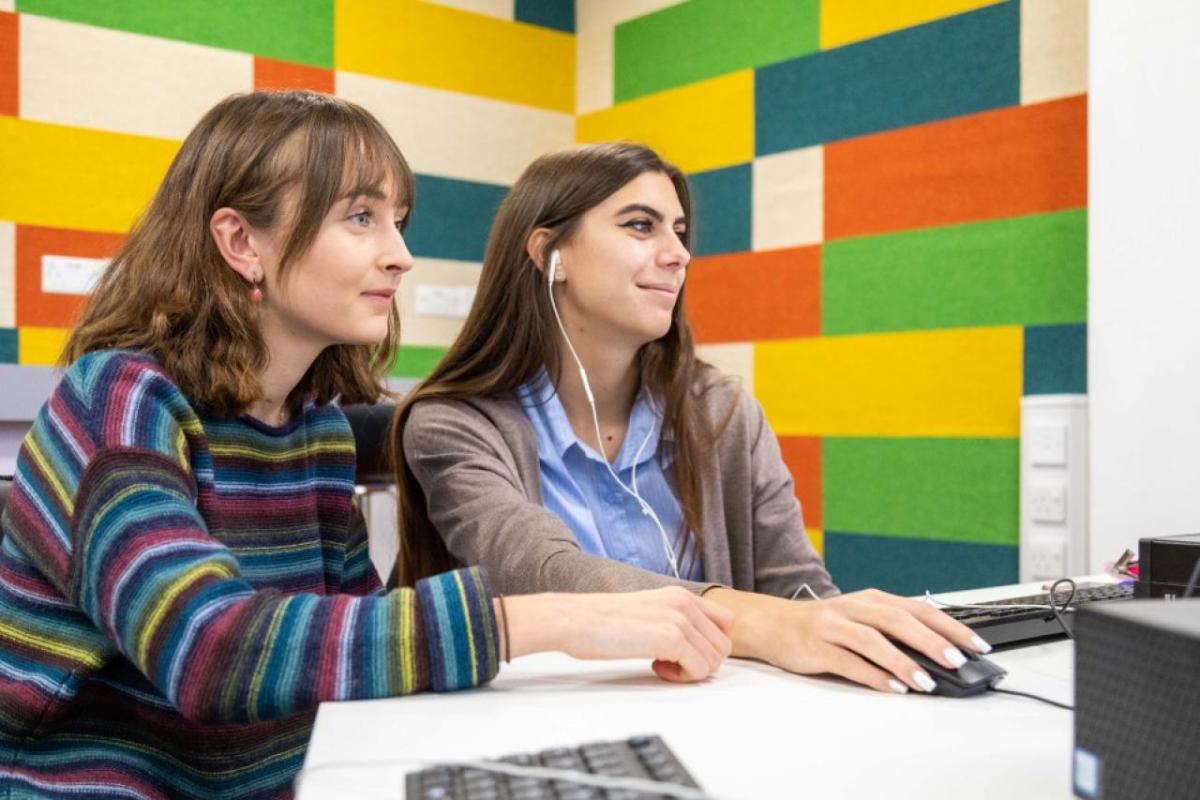 Two students working together at a computer 