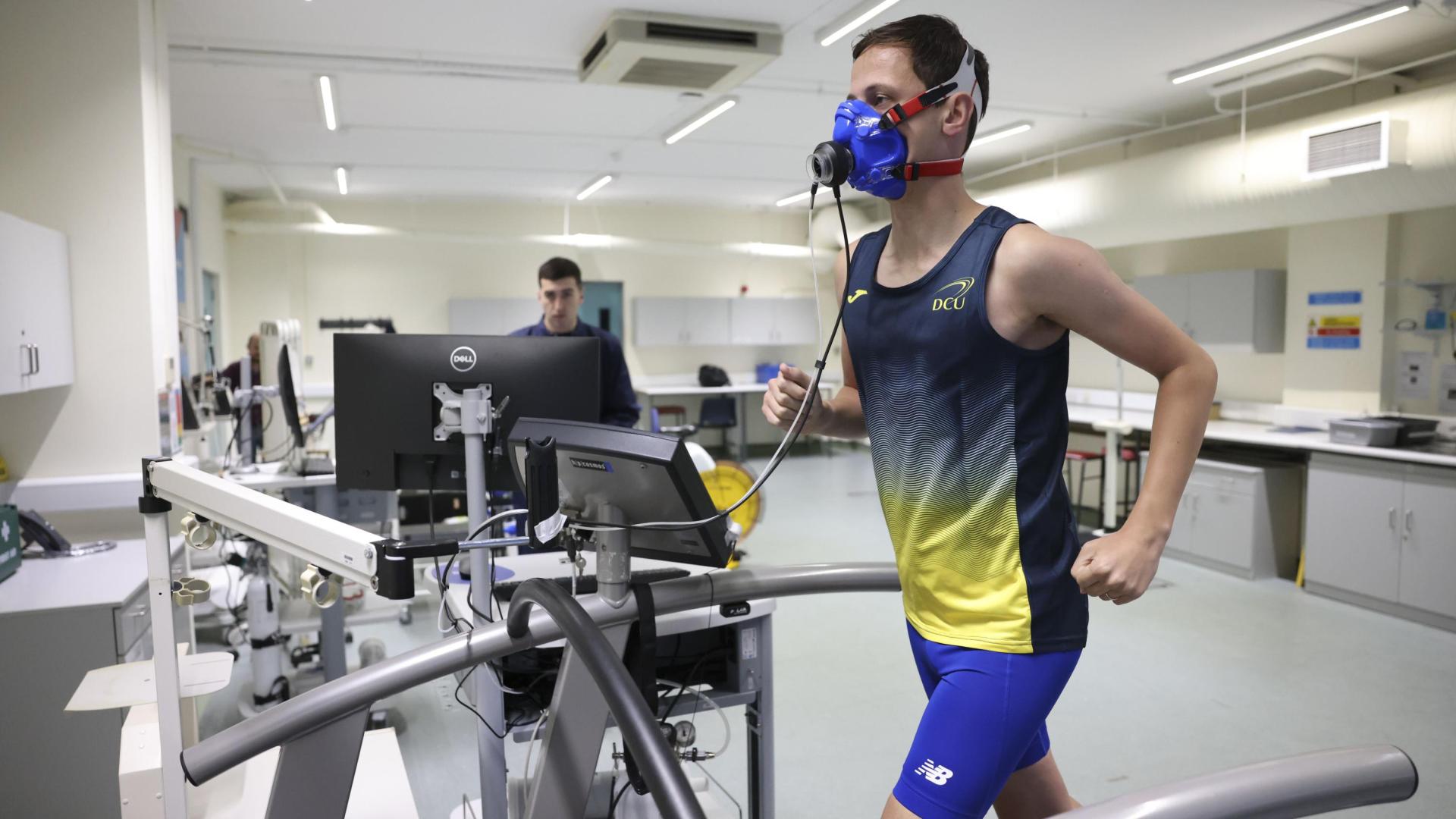Shows athlete running on treadmill as part of research study