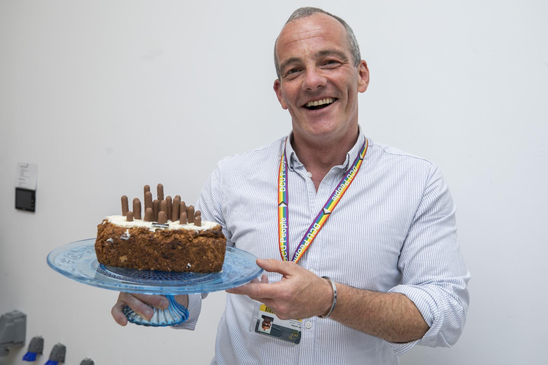 Shows Ian Bell with his banana bread for DCU Bake Off for Barretstown