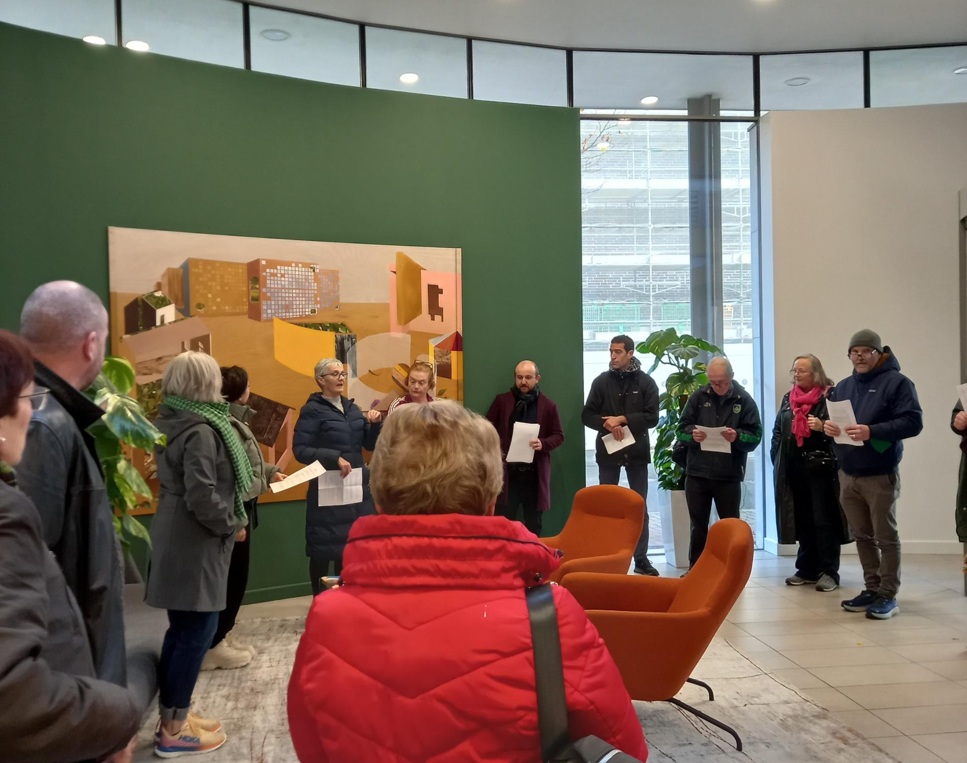 People gathered in a circle listening to a woman speak