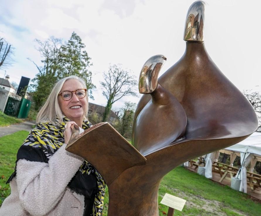 Artist Sandra Bell stands beside her artwork - teachers inspire sculpture. 